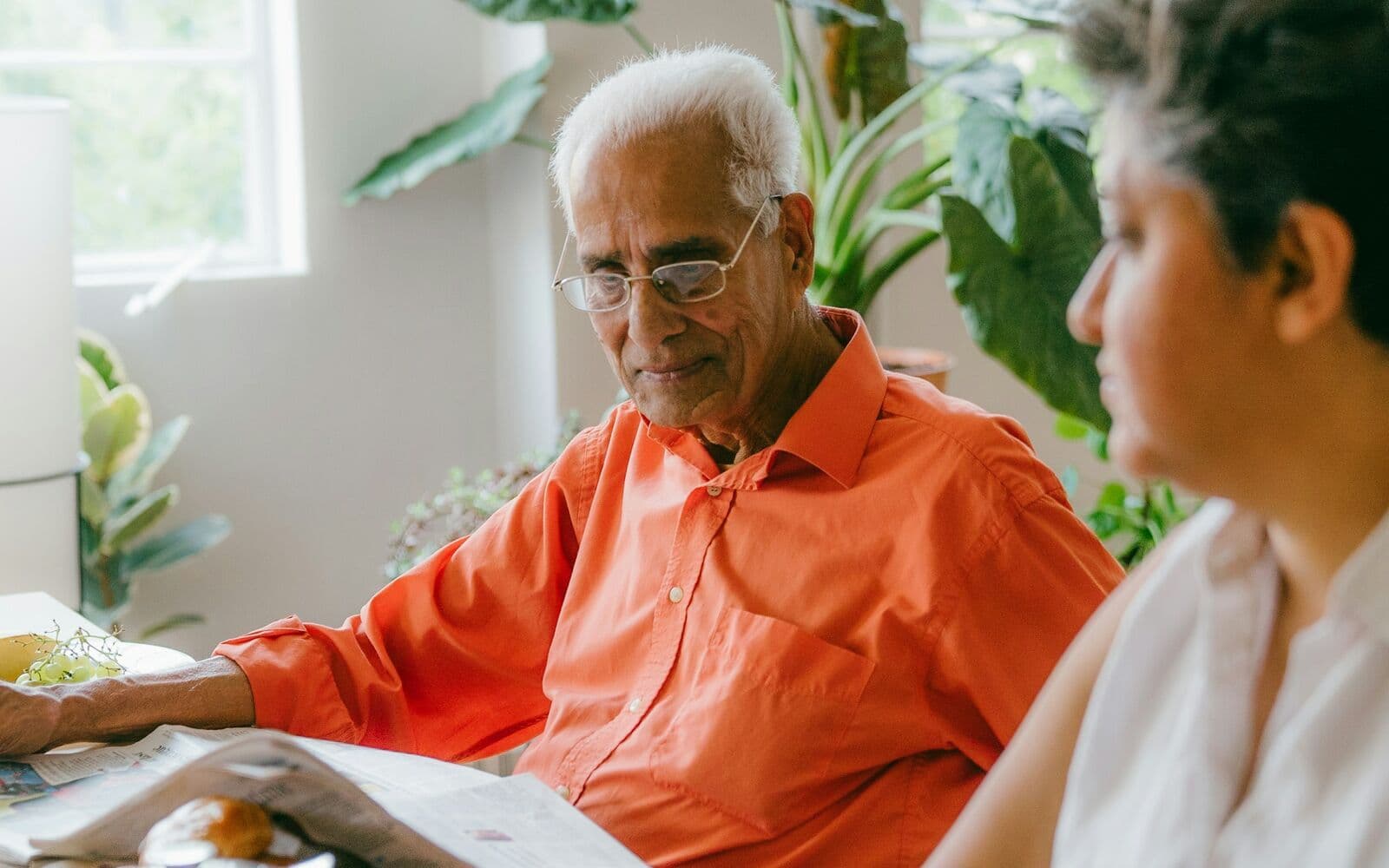 Une conseillère aide un homme âgé à relire des documents.