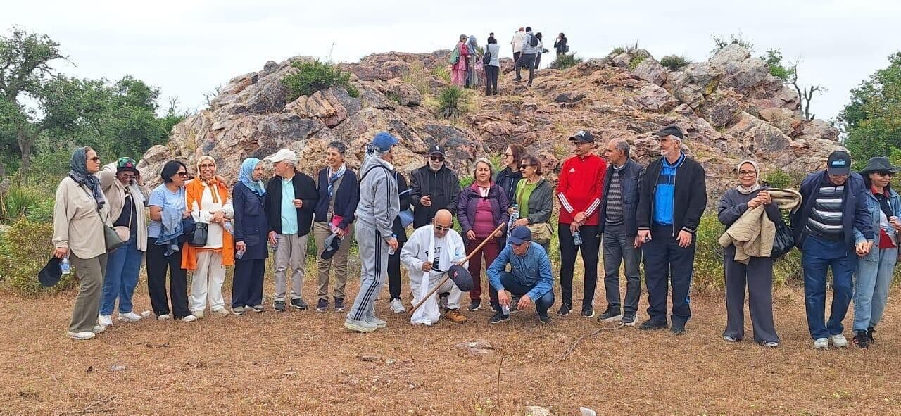 Groupe de retraités de Casablanca devant une colline rocheuse, lors de la sortie printanière à Benslimane.